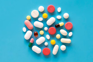 Colorful pills arranged in a circle on a blue surface