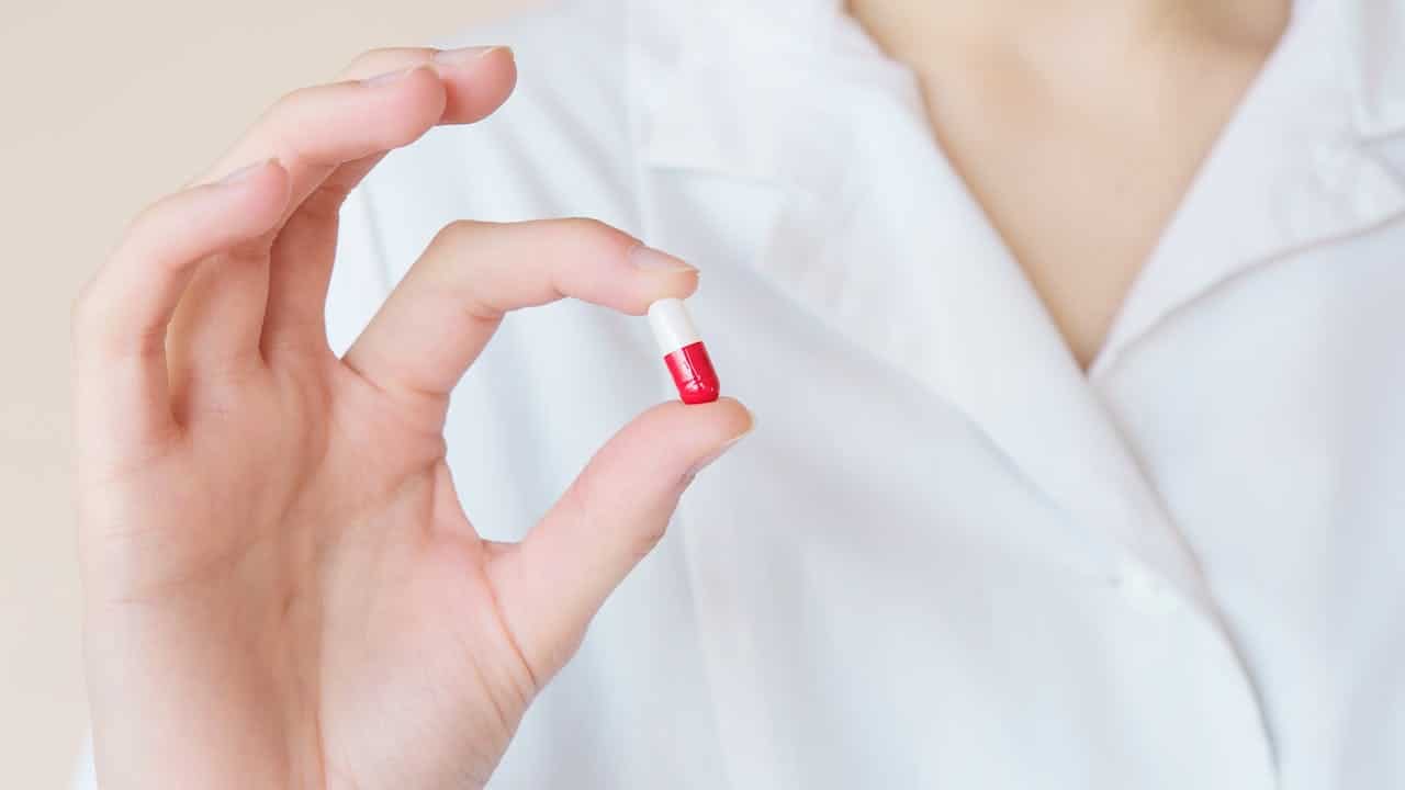 woman holding a pill