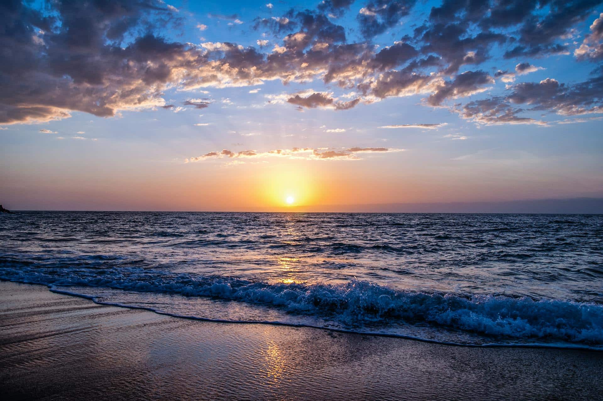 A beach with the Sun on the horizon