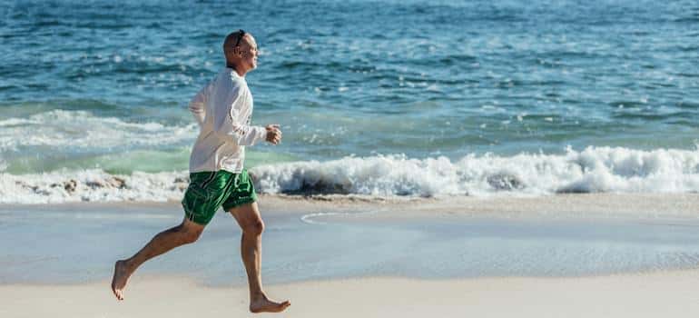 A person running on the beach, which is an example of how California's climate helps substance abuse recovery