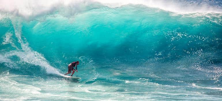 A person surfing, which is a great exercise and an example of California's climate helps substance abuse recovery