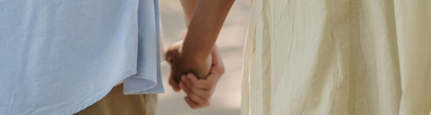 A couple holding hands symbolizing support needed when dating a recovering addict.