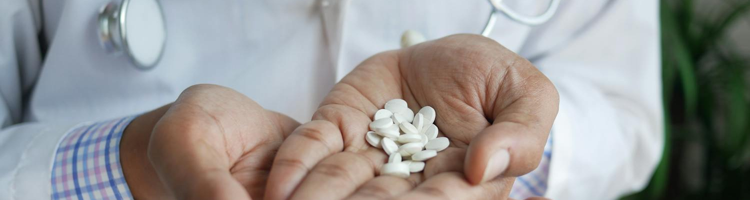 A doctor holding a bunch of pills. 